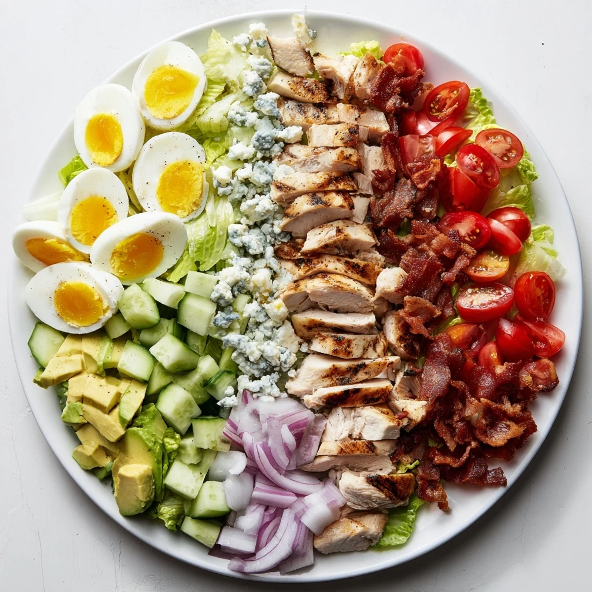 Hearty Cobb salad featuring crumbled blue cheese, cherry tomatoes, and golden hard-boiled egg quarters