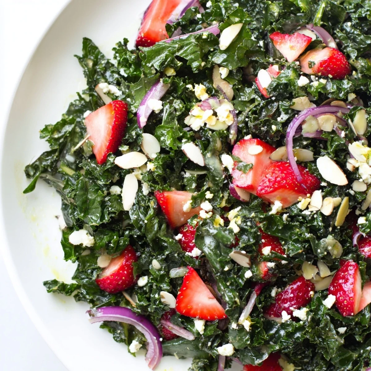 Fresh strawberry kale salad tossed in honey lemon dressing served in a rustic bowl