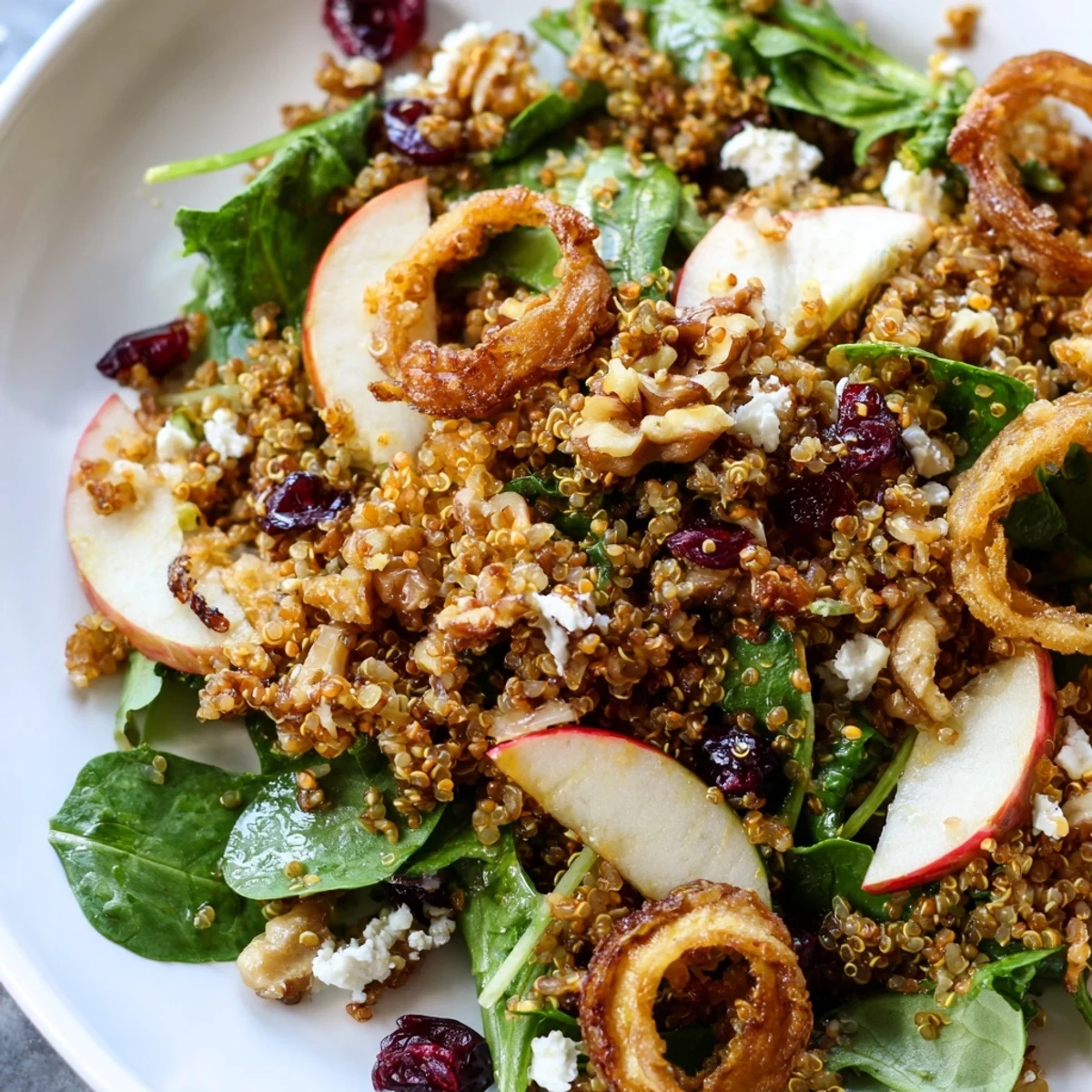 Honey Mustard Quinoa Apple Salad drizzled with golden dressing on a rustic wooden board