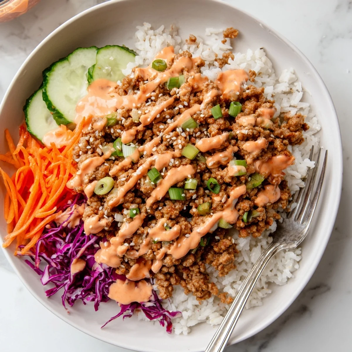 Hearty ground turkey rice bowls topped with colorful crisp veggies and creamy Bang Bang sauce
