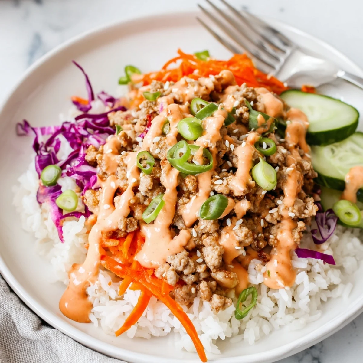 Steaming jasmine rice layered with savory ground turkey and drizzled with spicy Bang Bang sauce