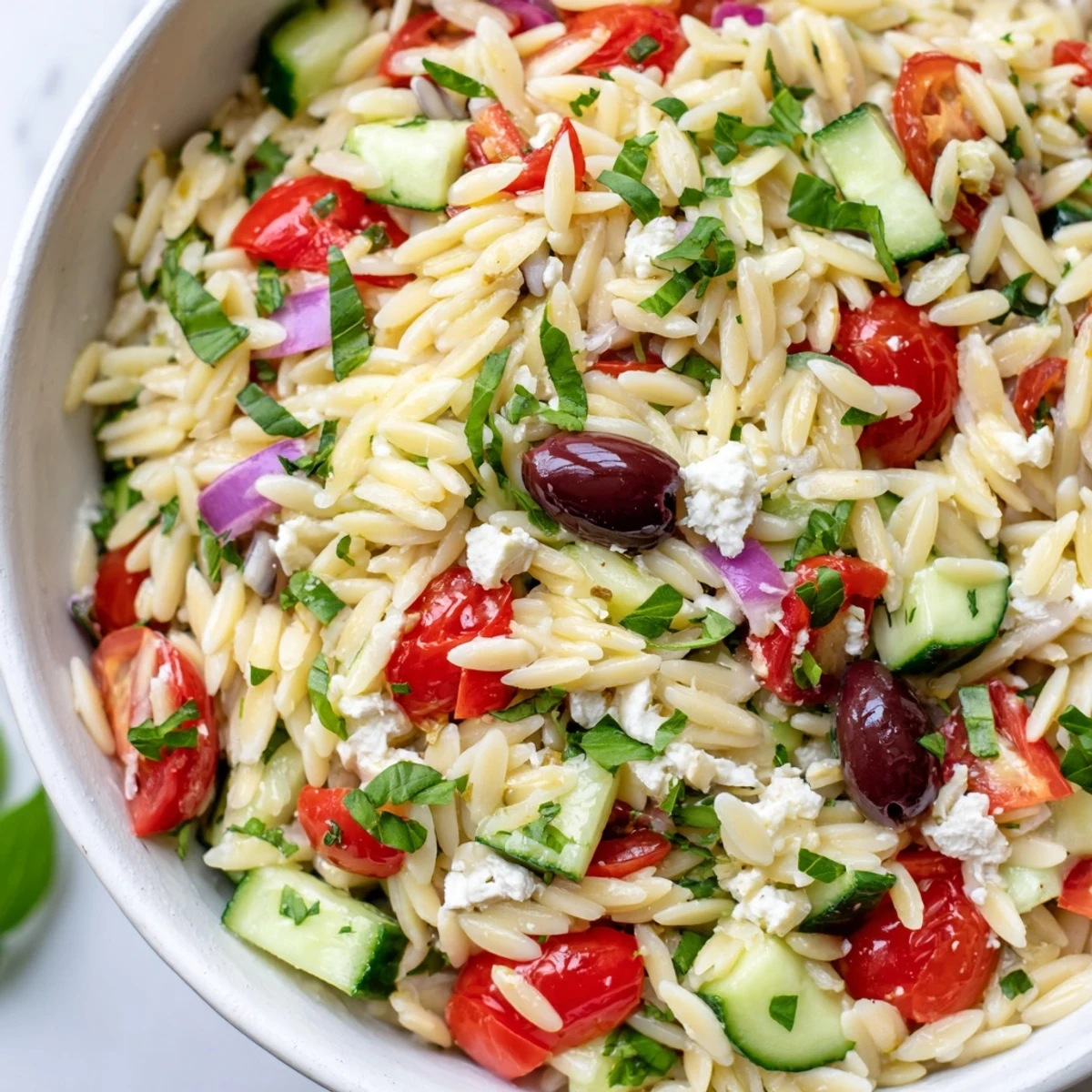 Mediterranean Orzo Pasta Salad tossed with fresh herbs, cucumbers, and tangy lemon dressing