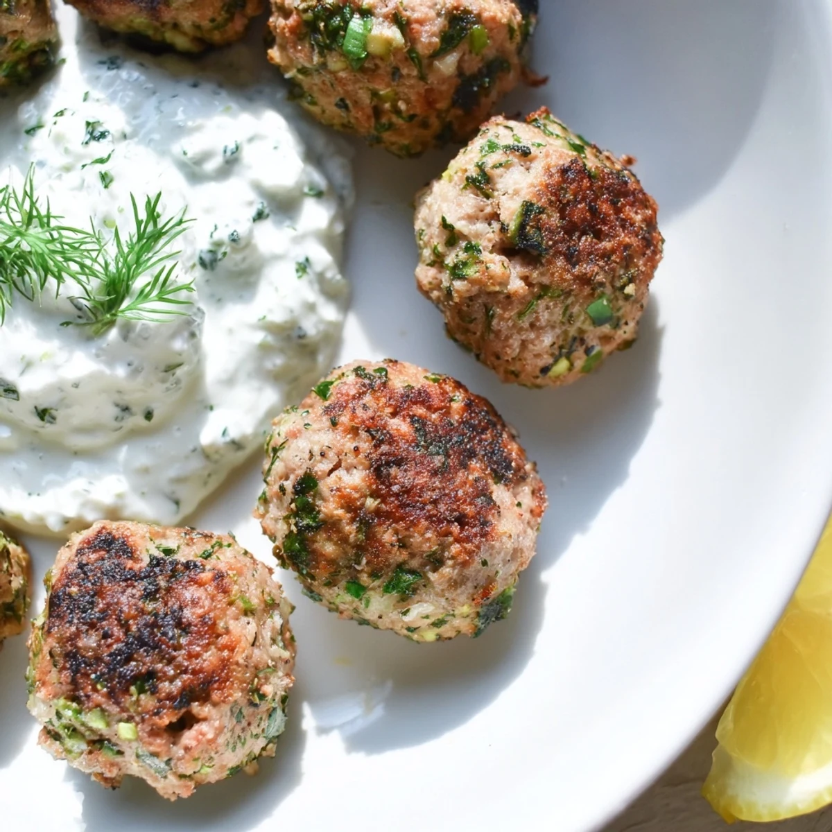 Crispy-baked Greek turkey meatballs arranged over fresh greens with a generous tzatziki dollop
