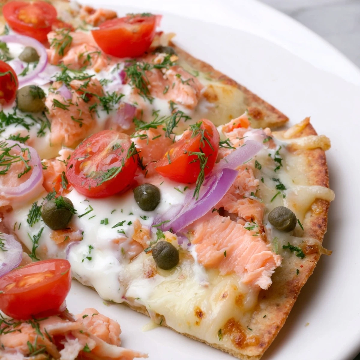 Golden crispy salmon tortilla pizza with melted mozzarella, fresh dill, and capers