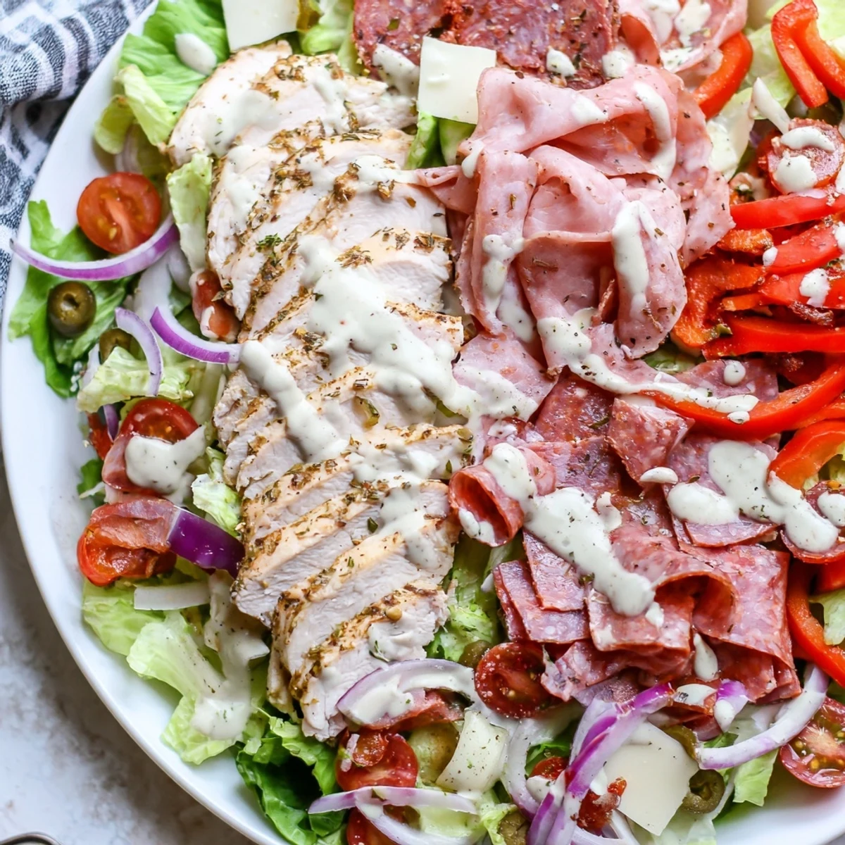 Creamy zesty dressing drizzled over Italian Grinder Chicken Salad with provolone and salami
