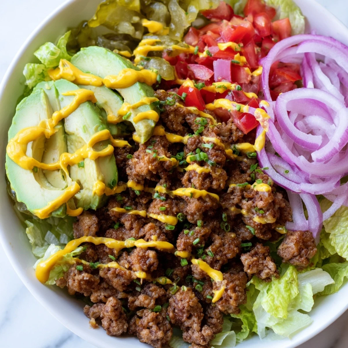 Hearty burger bowls featuring crumbled beef, diced tomatoes, and shredded cheese drizzled with mustard