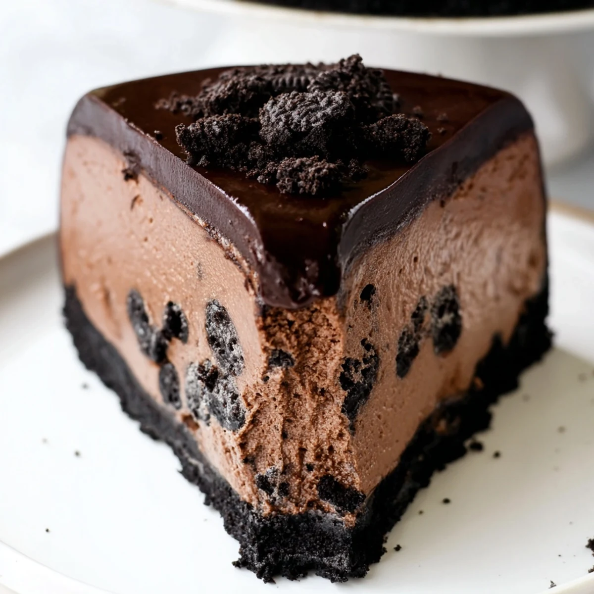 Creamy Oreo chocolate cheesecake sliced and topped with glossy dark ganache