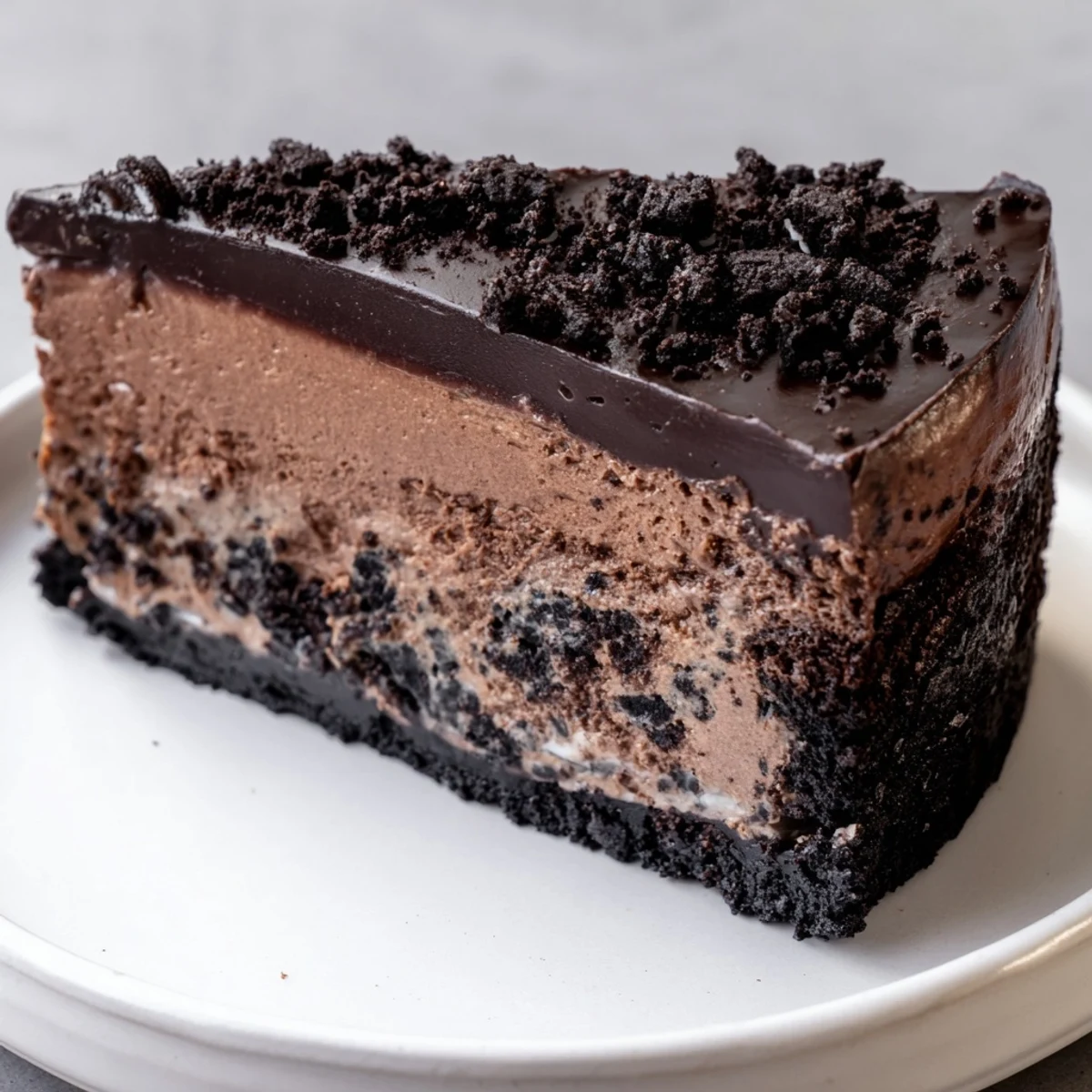 Rich Oreo chocolate cheesecake with a thick cookie crust on a dessert plate