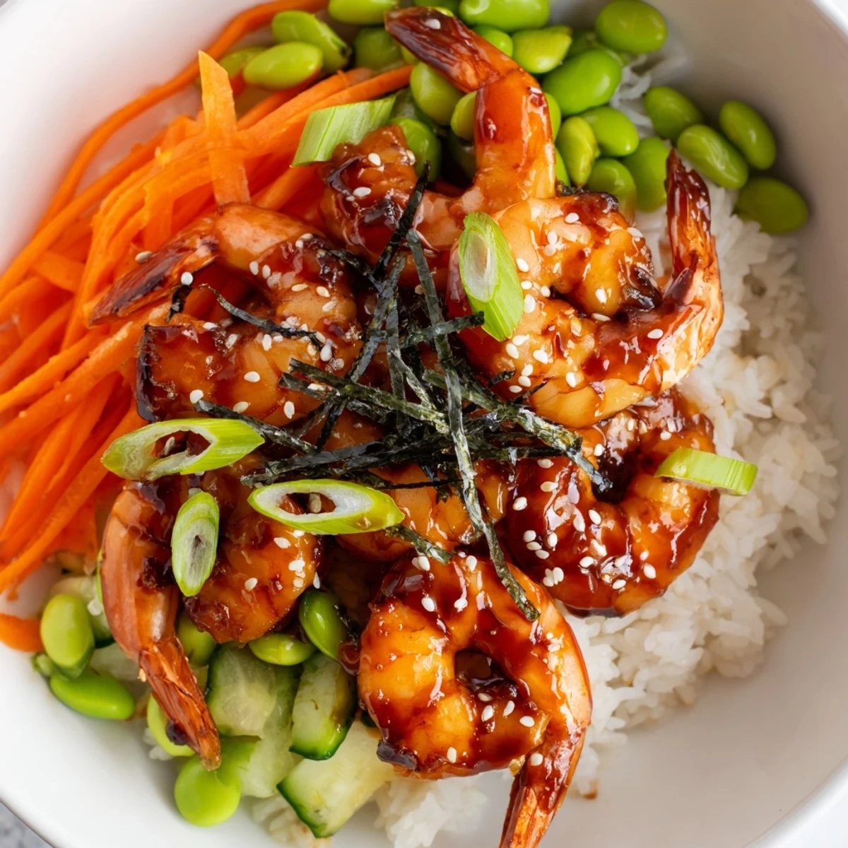 Succulent glazed shrimp nestled in a savory bowl with crisp veggie garnishes.