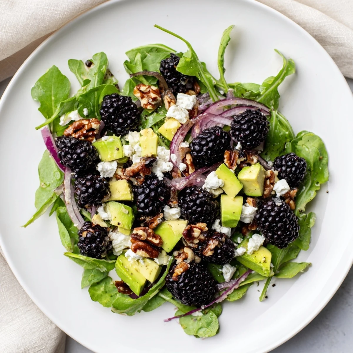 Fresh Blackberry Avocado Salad drizzled with honey-lime dressing and crunchy toasted nuts.