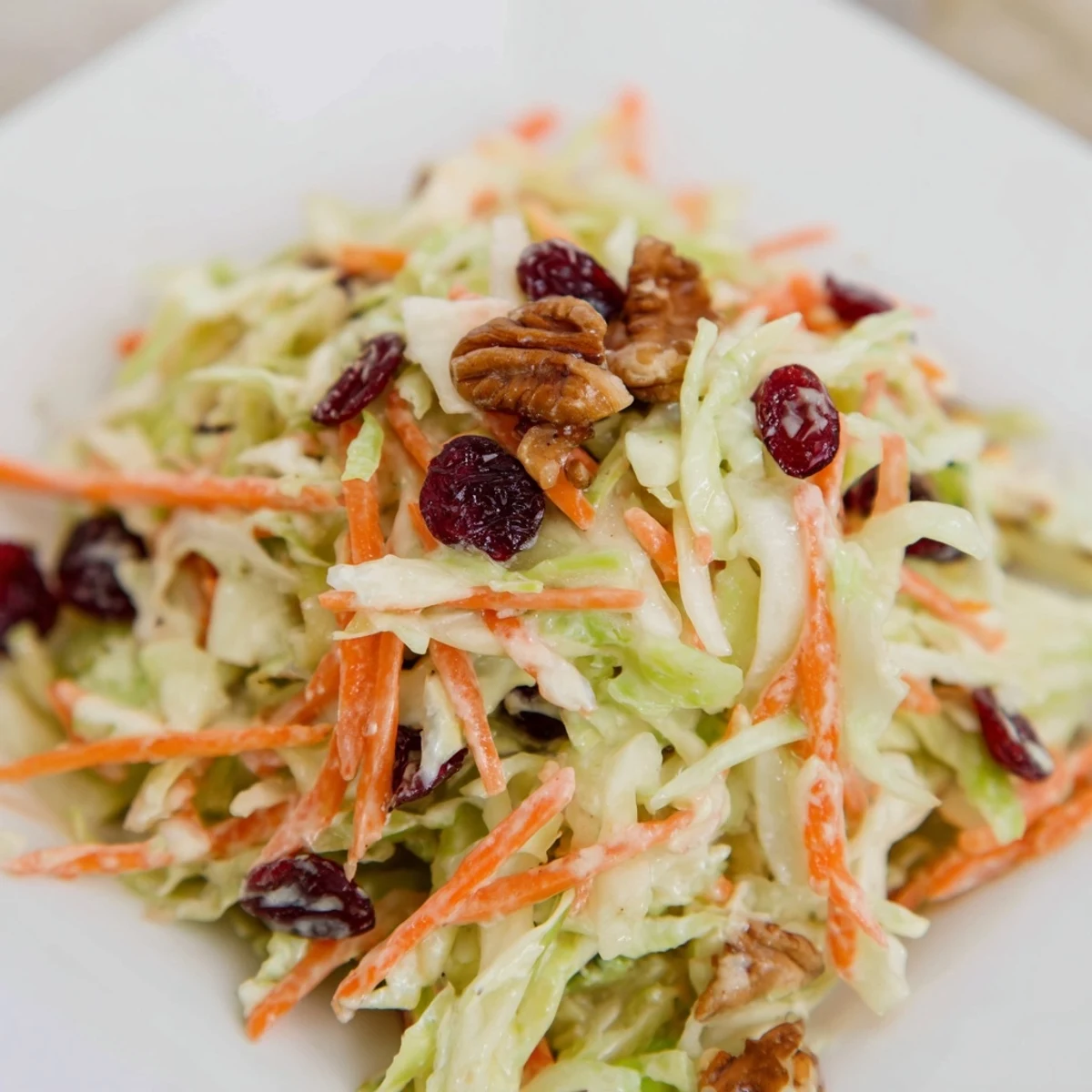 Refreshing cranberry apple coleslaw served chilled, showcasing a vibrant mix of red cabbage and apples.