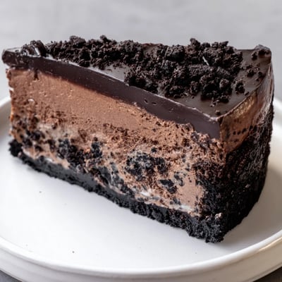 Rich Oreo chocolate cheesecake with a thick cookie crust on a dessert plate